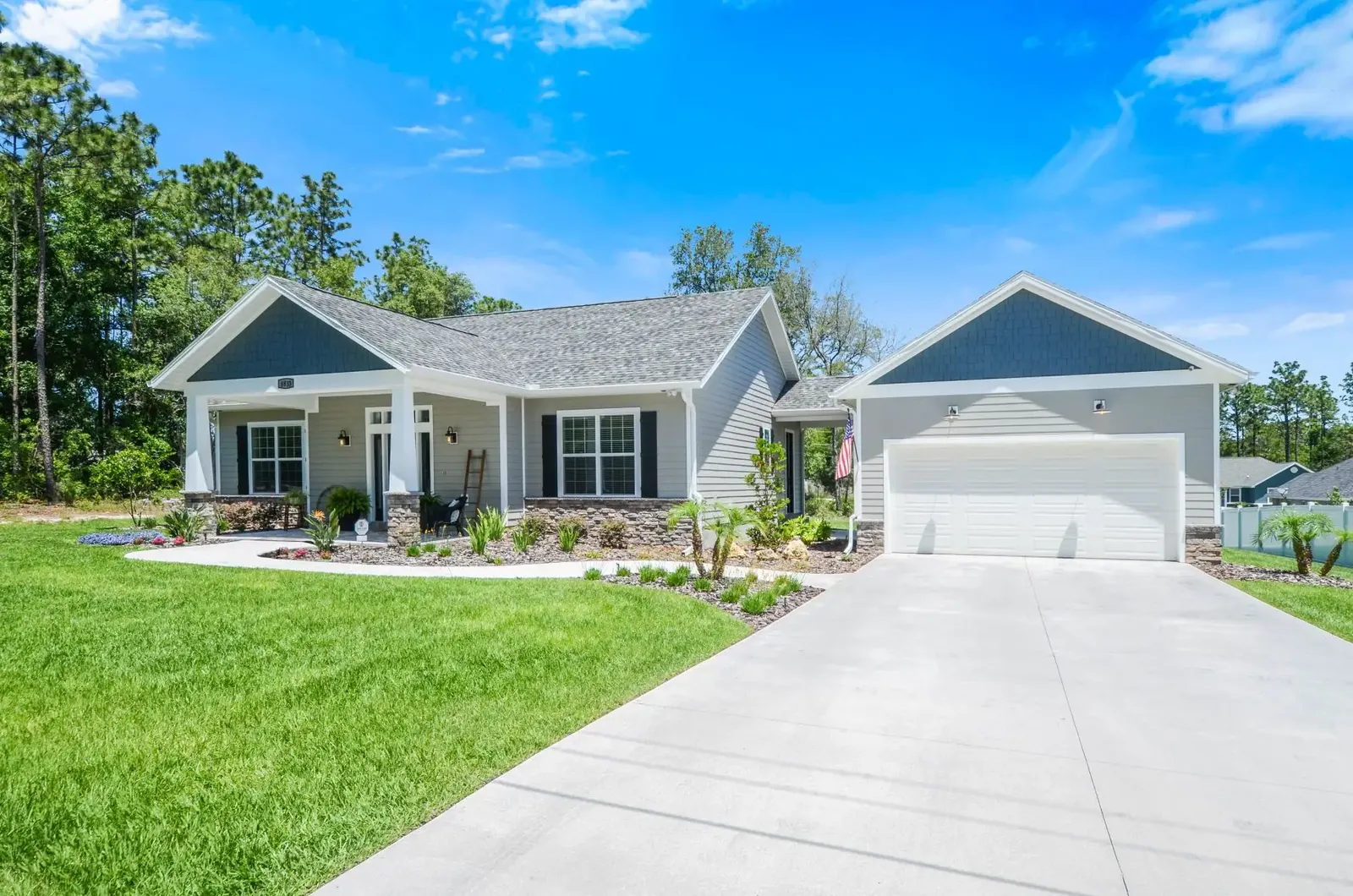 Craftsman-style custom home with a blue gable, stone accents and a two-car garage
