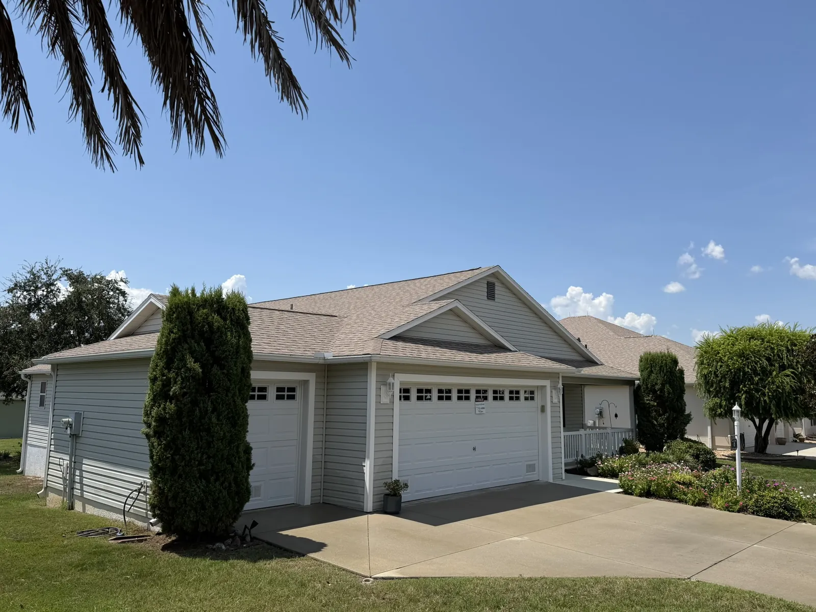 Completed light gray shingle roof on a home with a two-car garage