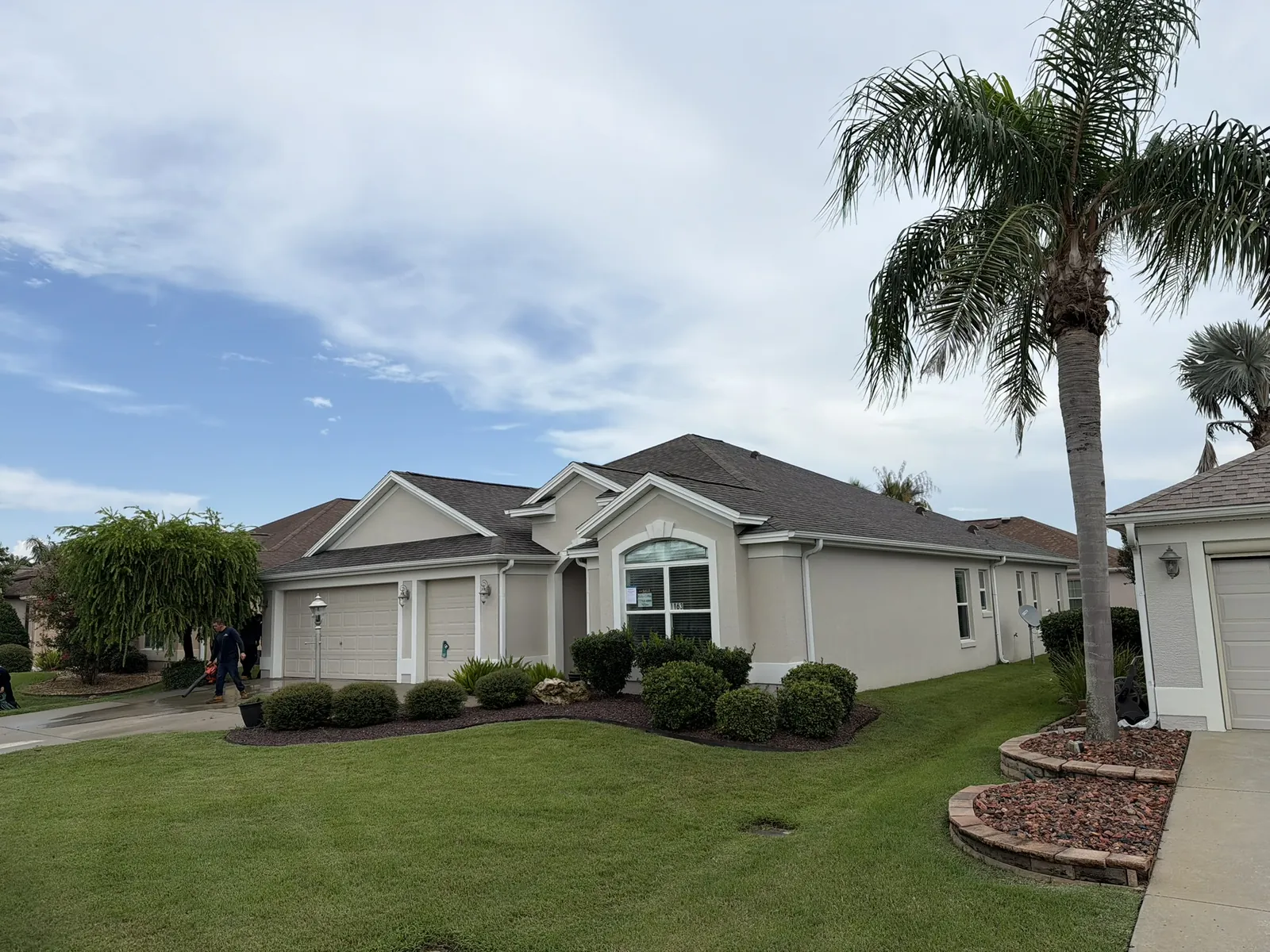 Finished shingle roof on a landscaped home with palm trees